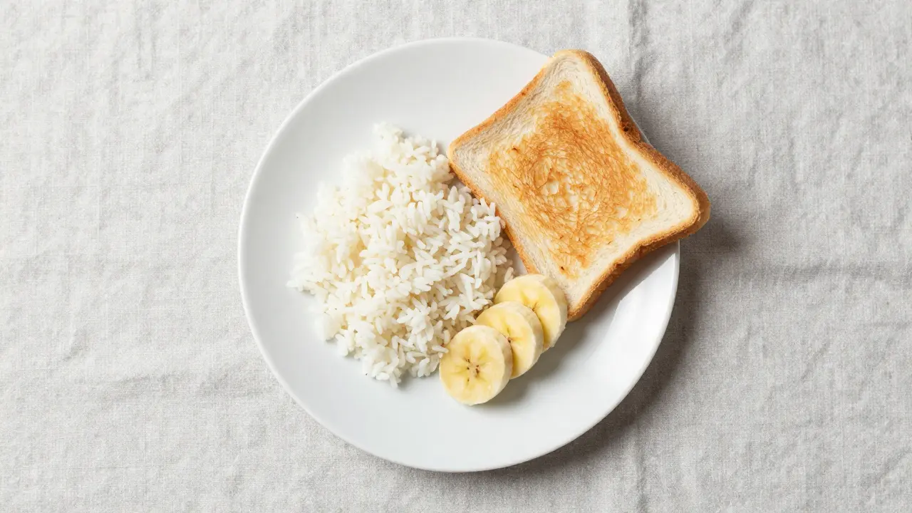Talíř s rýží, banánem a toastem jako součást šetrné BRAT diety.